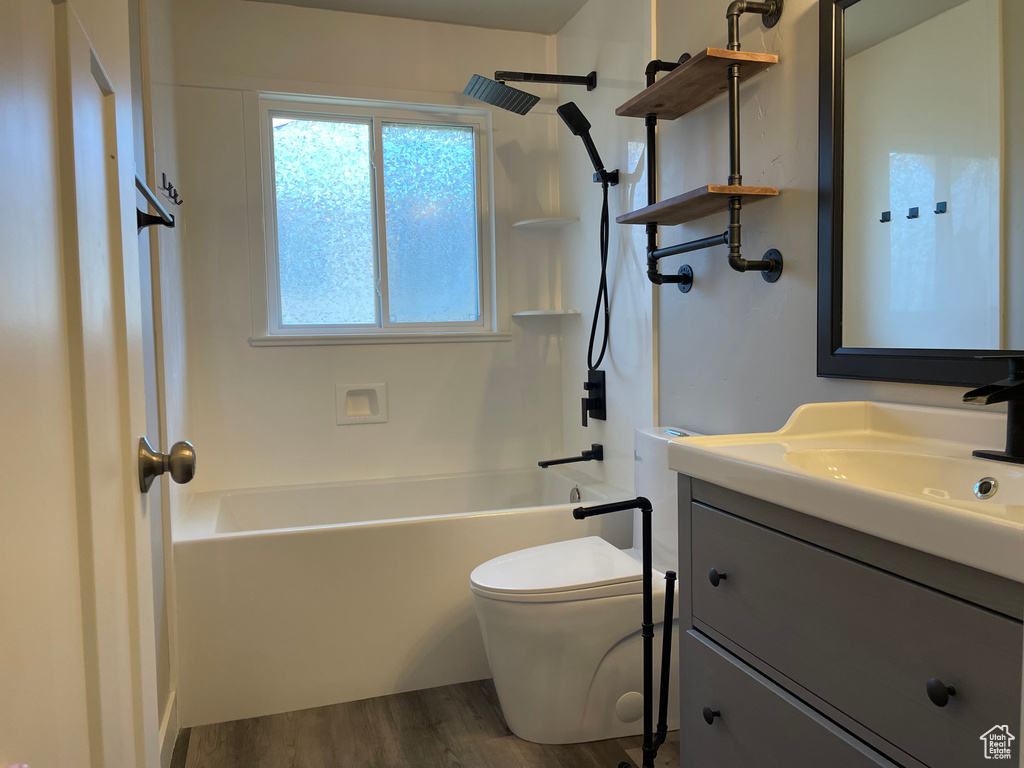 Full bathroom featuring shower / bathing tub combination, hardwood / wood-style flooring, toilet, and vanity