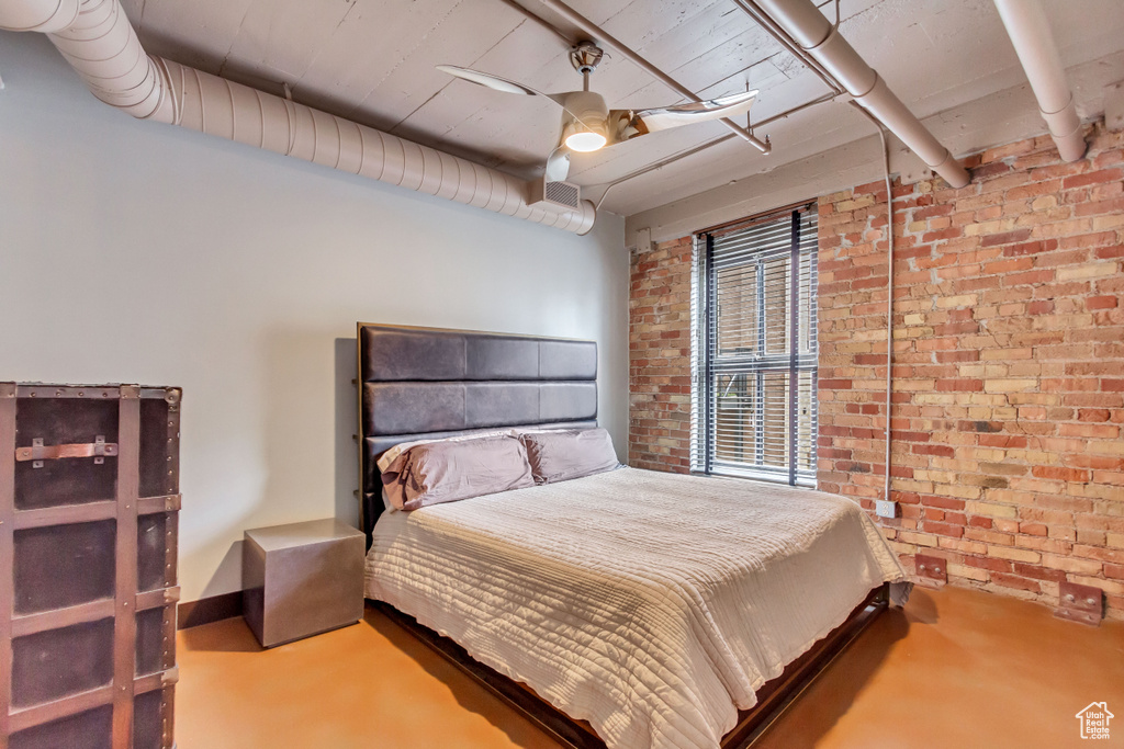 Bedroom featuring brick wall and ceiling fan