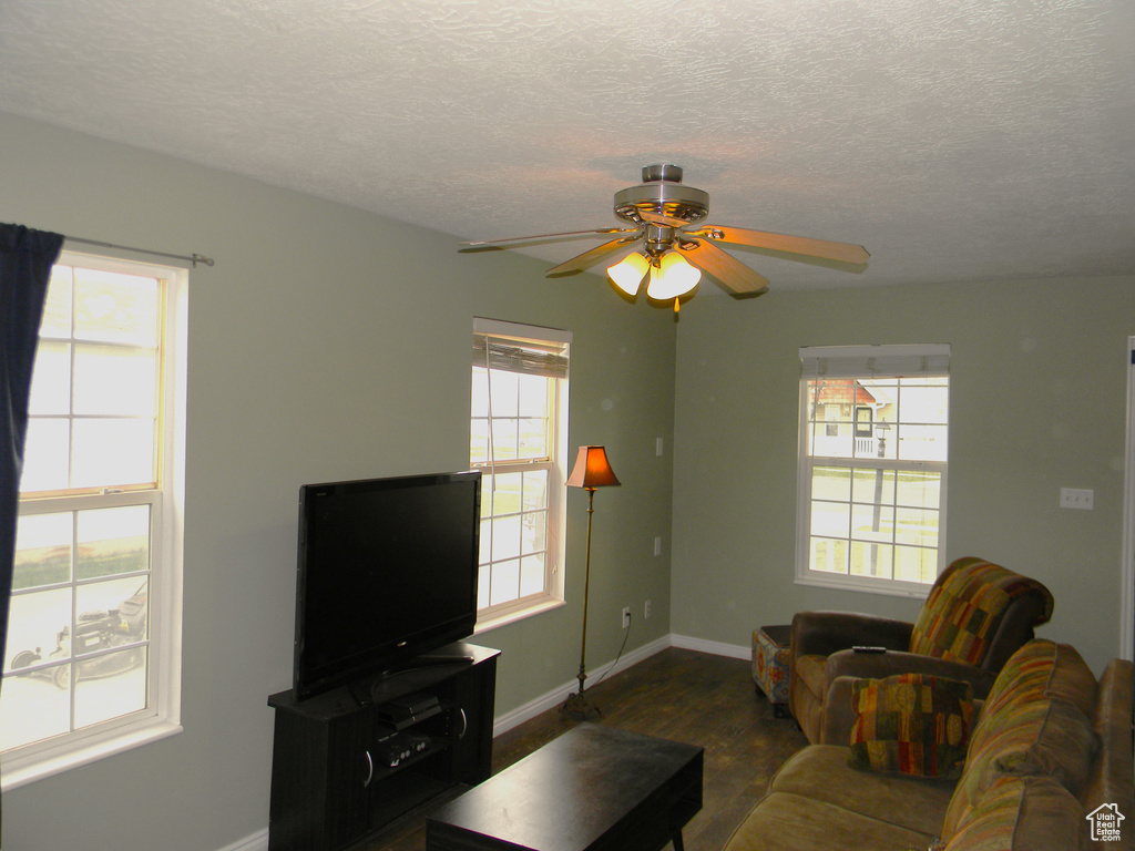 Living room featuring ceiling fan and a textured ceiling