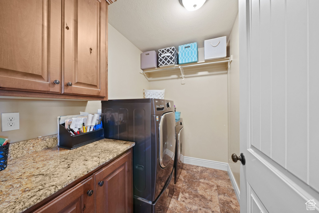 Laundry room featuring cabinets and light tile floors