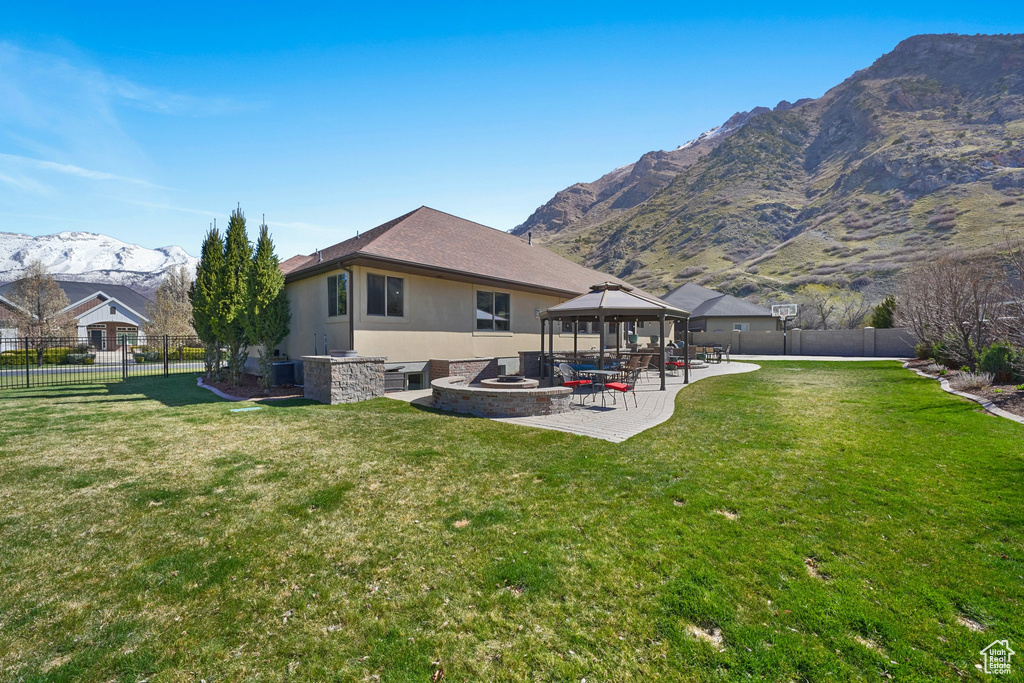 Rear view of property with a fire pit, a gazebo, central AC unit, a patio, and a mountain view
