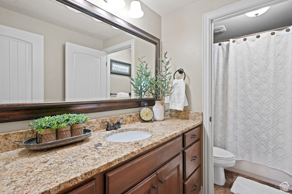 Full bathroom with toilet, oversized vanity, shower / bath combination with curtain, and tile flooring