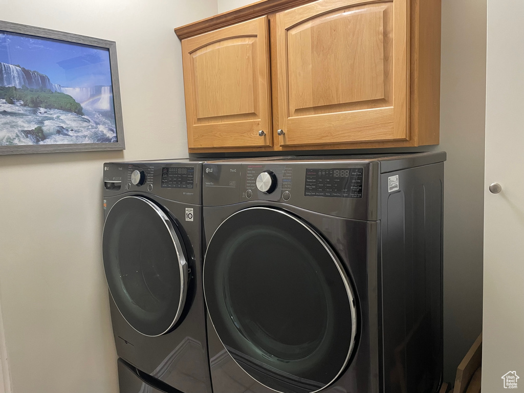 Laundry area featuring cabinets and separate washer and dryer