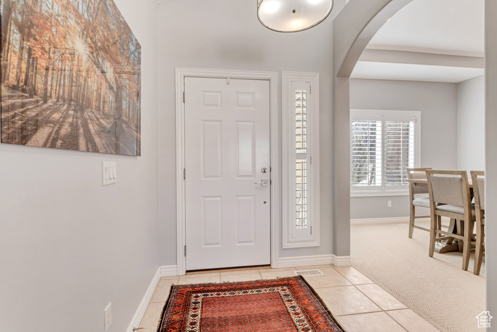 Foyer entrance featuring light colored carpet