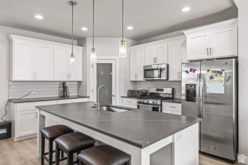 Kitchen with hanging light fixtures, tasteful backsplash, sink, and stainless steel appliances