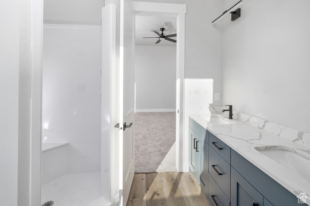 Bathroom with double vanity, ceiling fan, and hardwood / wood-style floors