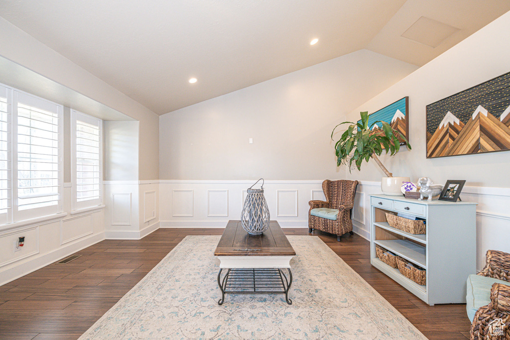 Sitting room with lofted ceiling and dark hardwood / wood-style floors