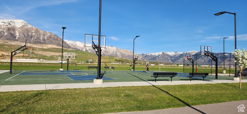 View of basketball court featuring a mountain view and a lawn