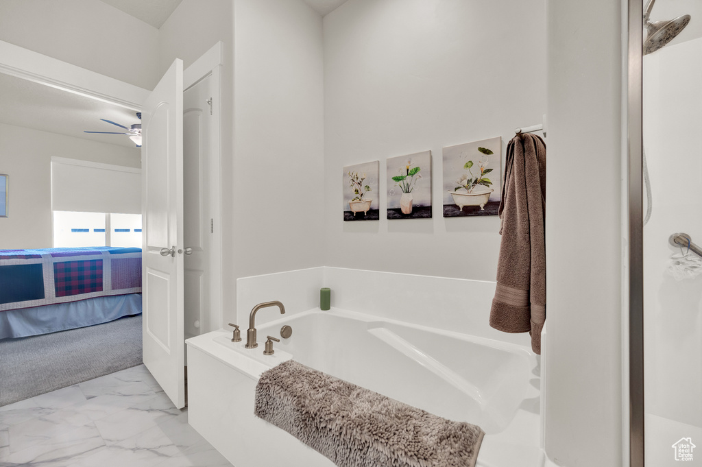 Bathroom featuring tile floors, ceiling fan, and a tub