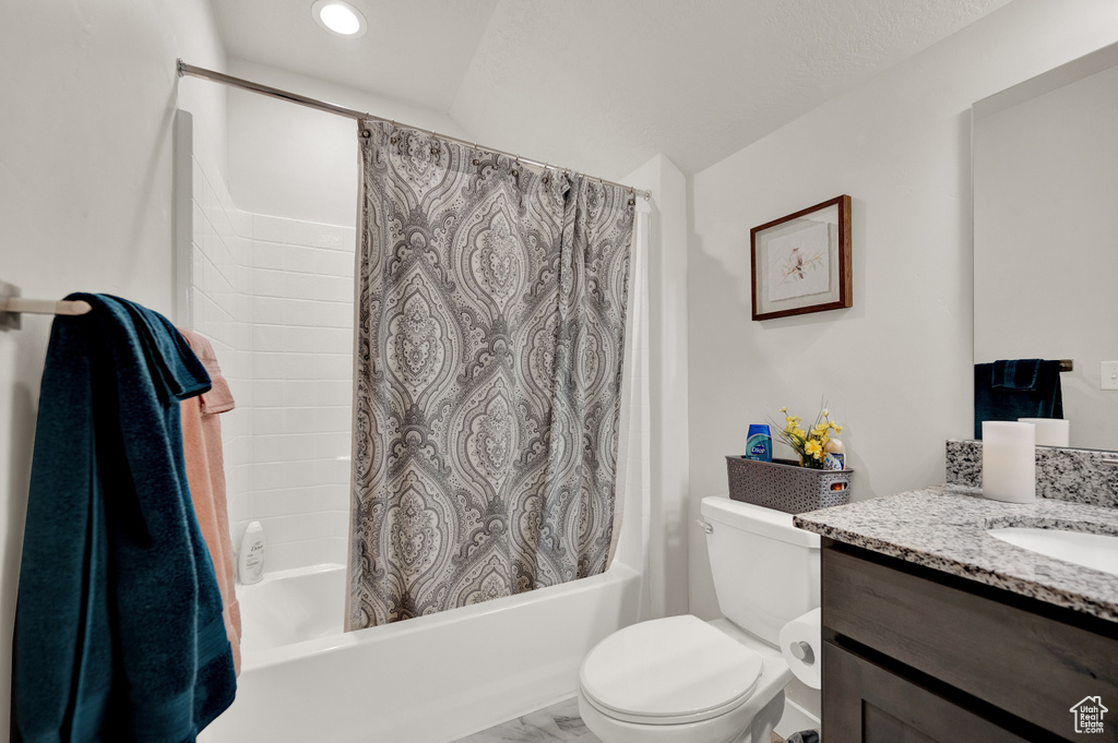 Full bathroom with toilet, oversized vanity, and shower / tub combo with curtain