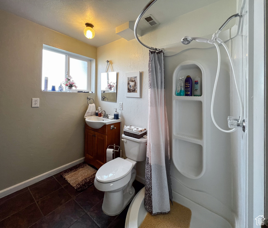Full bathroom featuring shower / tub combo, toilet, tile flooring, and vanity