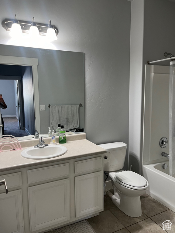Full bathroom with large vanity, toilet, tile flooring, and shower / bathtub combination