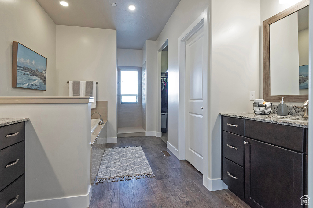 Bathroom featuring hardwood / wood-style floors, vanity, and a bathtub