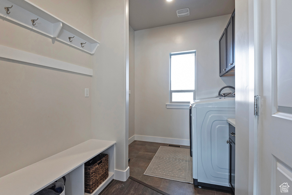 Interior space featuring dark tile flooring and washer / dryer