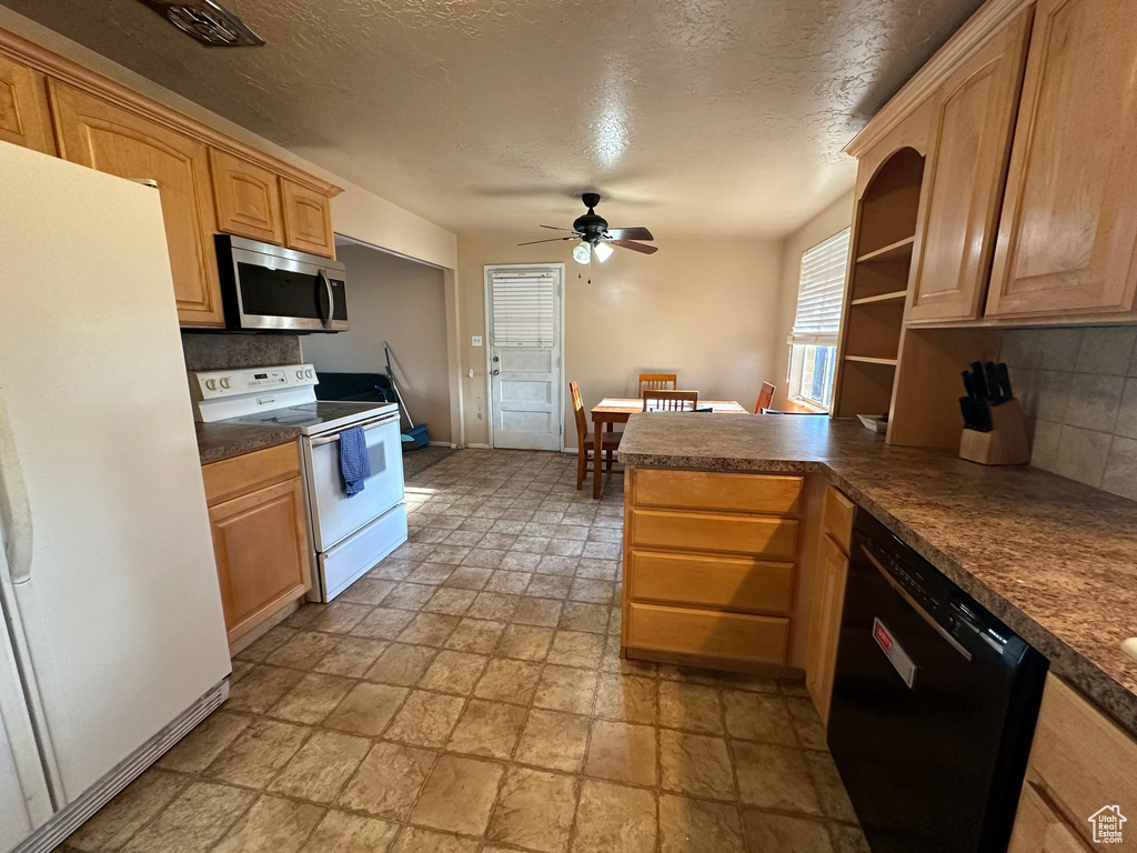 Kitchen featuring white appliances, kitchen peninsula, light tile floors, tasteful backsplash, and ceiling fan