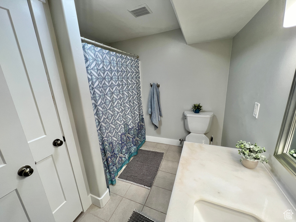 Bathroom featuring tile flooring, sink, and toilet