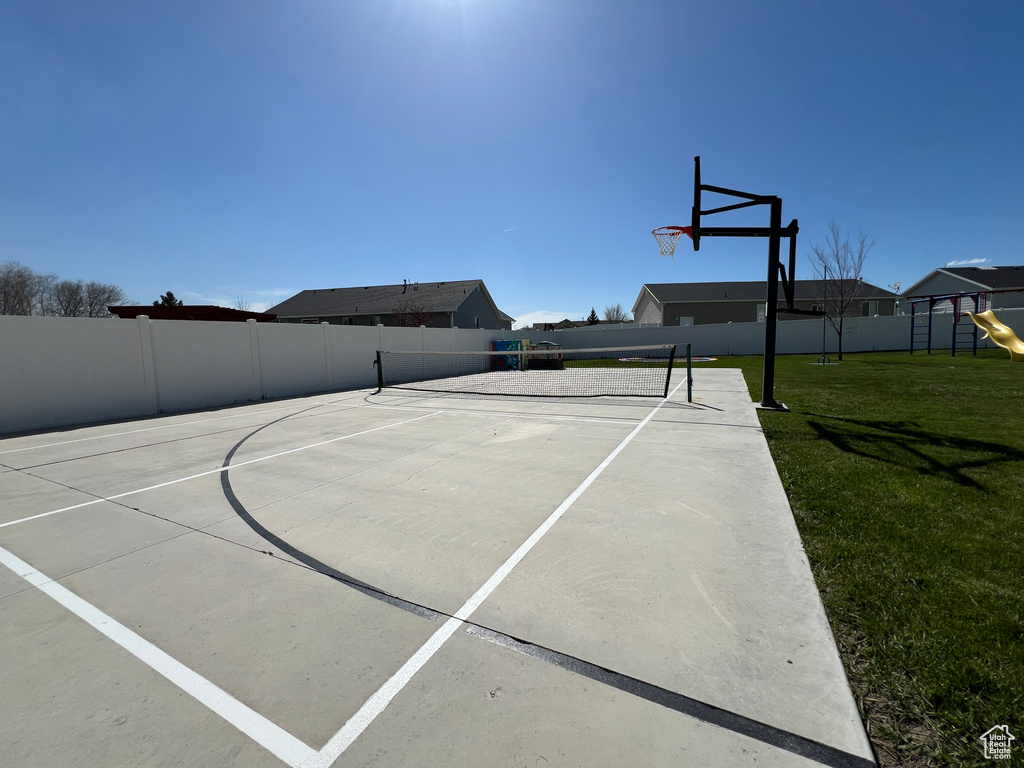 View of basketball court with a lawn and a playground