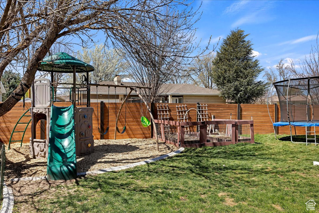 View of jungle gym featuring a trampoline and a yard