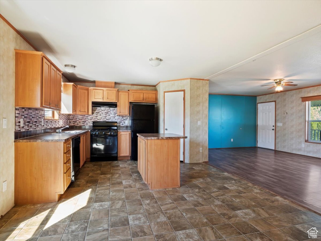 Kitchen with dark tile floors, black appliances, a kitchen island, tasteful backsplash, and ceiling fan