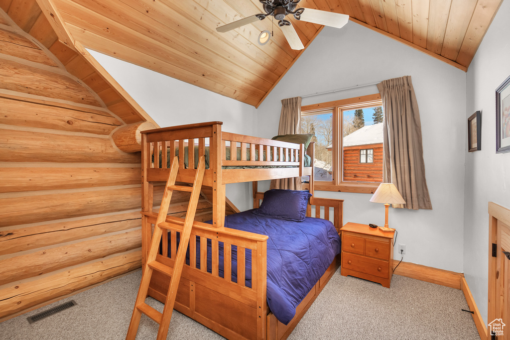 Carpeted bedroom featuring lofted ceiling, ceiling fan, rustic walls, and wood ceiling