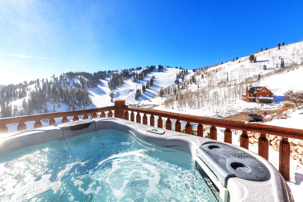 Snow covered pool featuring an outdoor hot tub