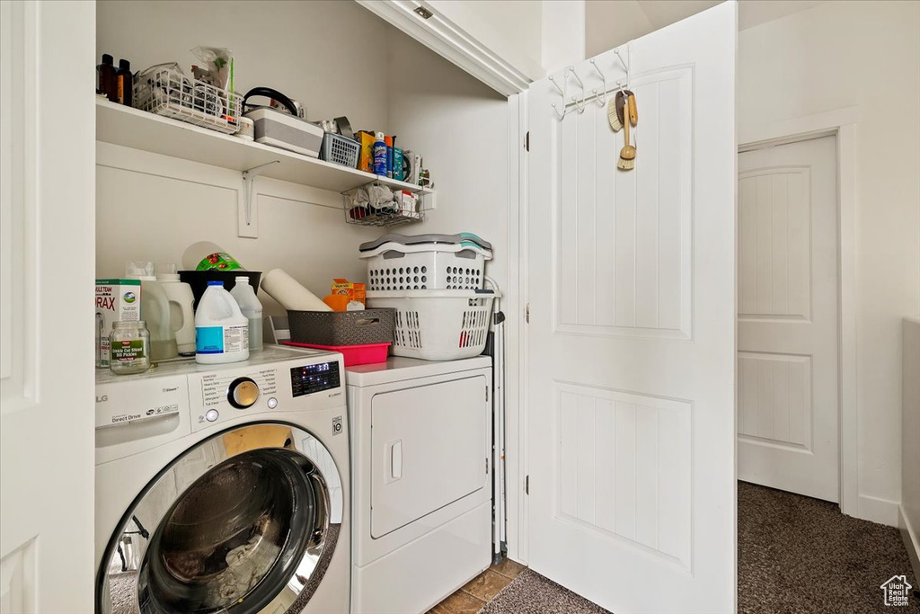 Laundry area featuring dark colored carpet and washer and dryer