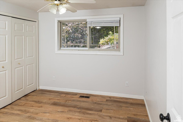 Unfurnished bedroom with a closet, light hardwood / wood-style floors, and ceiling fan