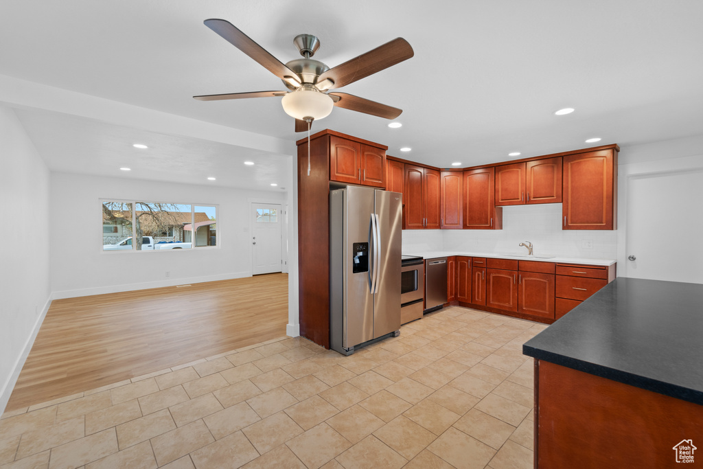 Kitchen featuring stainless steel fridge with ice dispenser, ceiling fan, light tile flooring, electric range, and sink