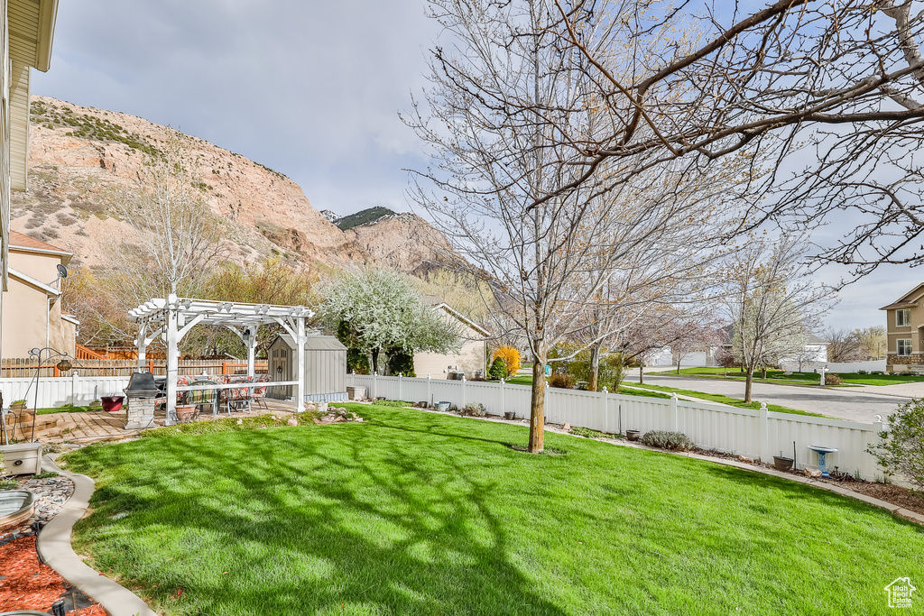 View of yard featuring a patio, a pergola, and a mountain view