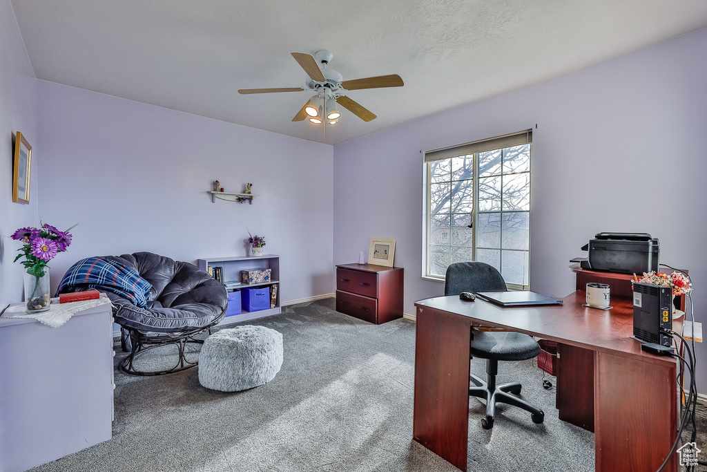 Office area with ceiling fan and dark carpet