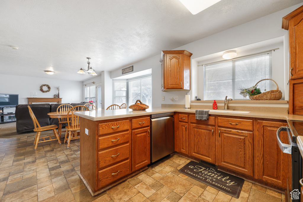 Kitchen with decorative light fixtures, light tile flooring, dishwasher, and kitchen peninsula