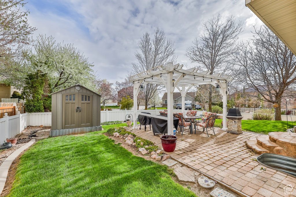 View of yard featuring a patio, a pergola, and a storage shed