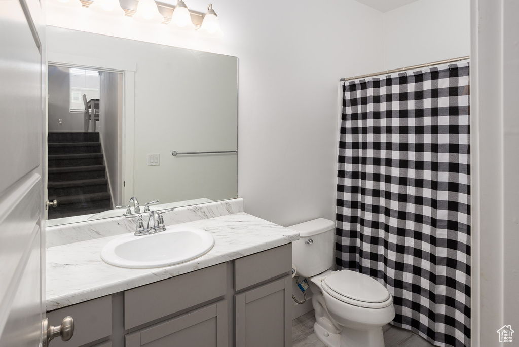 Bathroom with vanity with extensive cabinet space and toilet