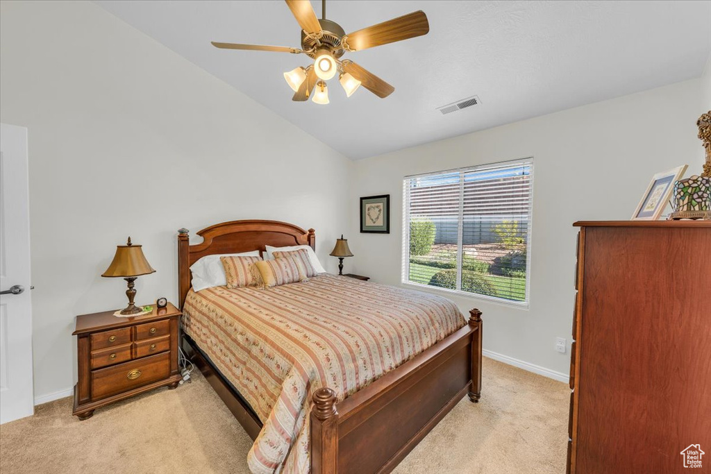 Carpeted bedroom with ceiling fan and lofted ceiling