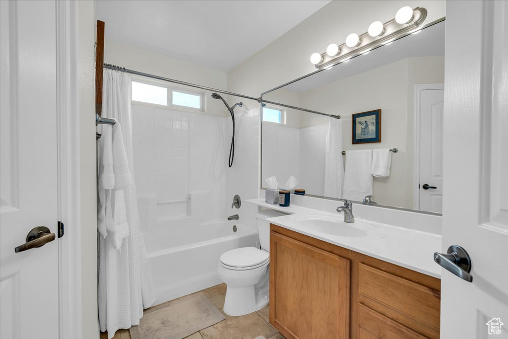 Full bathroom with tile flooring, shower / bathtub combination with curtain, toilet, and vanity
