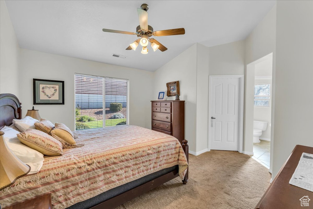 Bedroom with ceiling fan, multiple windows, light carpet, and vaulted ceiling