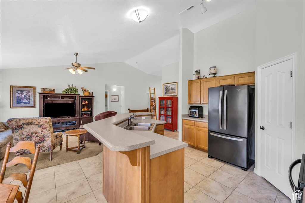 Kitchen featuring ceiling fan, fridge, sink, and light tile flooring