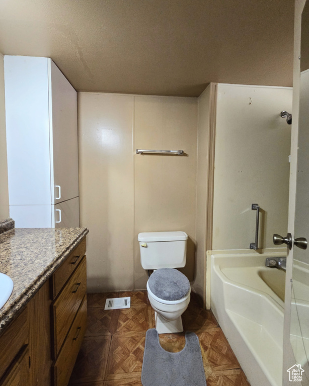 Full bathroom featuring shower / bathtub combination, parquet floors, vanity, and toilet