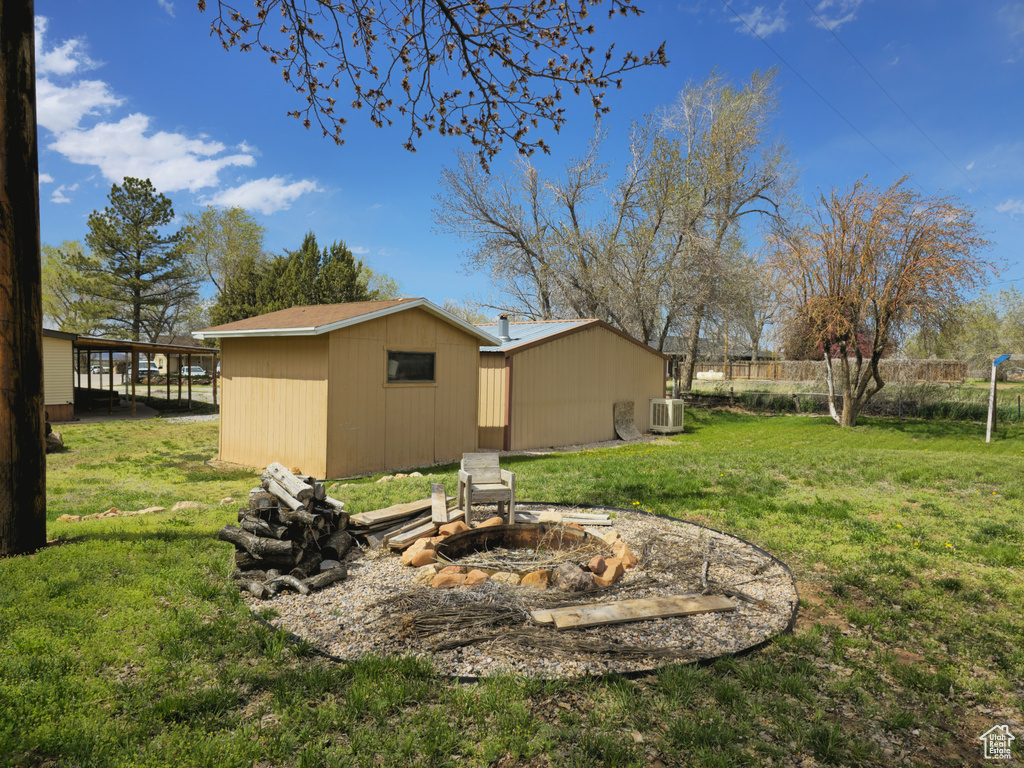 View of yard featuring a fire pit and central air condition unit
