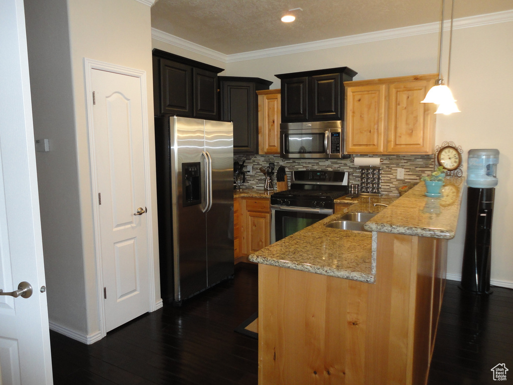 Kitchen with pendant lighting, crown molding, dark wood-type flooring, backsplash, and stainless steel appliances
