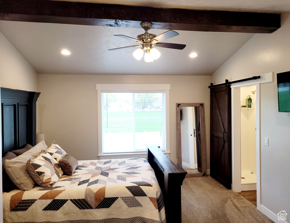 Carpeted bedroom with ceiling fan, lofted ceiling with beams, and a barn door