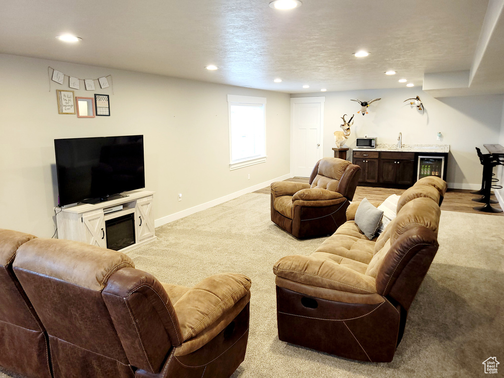 Carpeted living room featuring beverage cooler