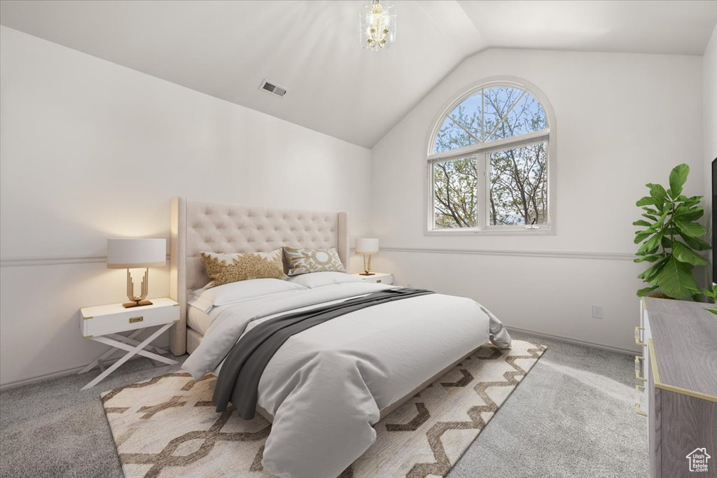 Carpeted bedroom featuring lofted ceiling and a chandelier
