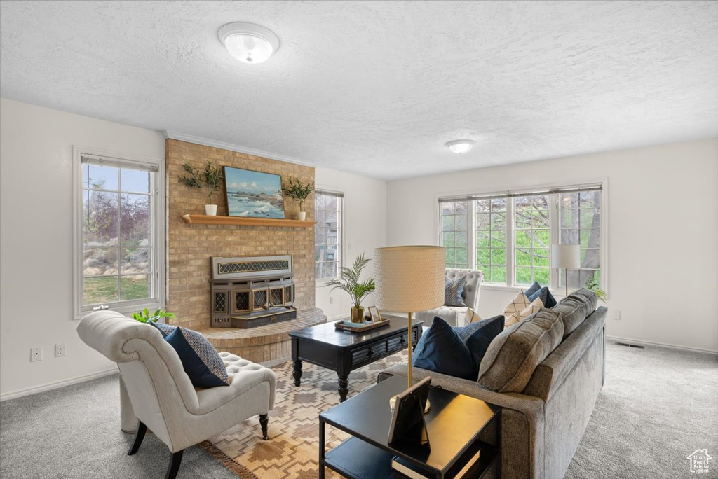 Living room featuring plenty of natural light, light colored carpet, and a brick fireplace