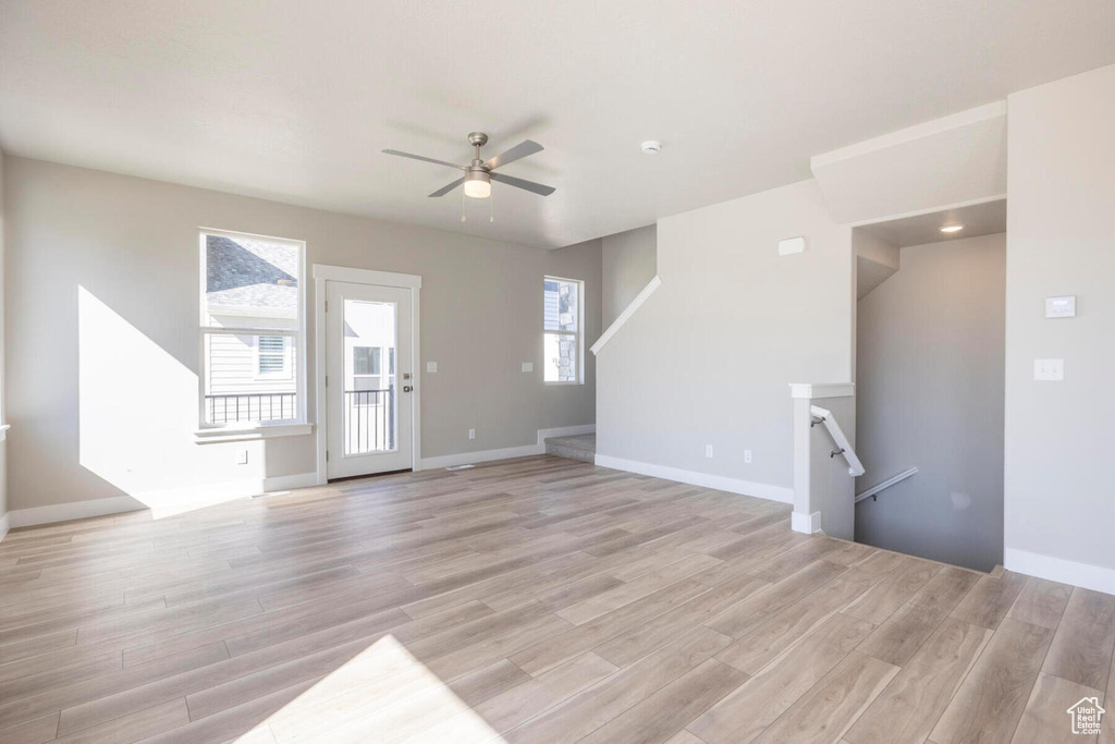 Spare room featuring plenty of natural light, ceiling fan, and light hardwood / wood-style floors
