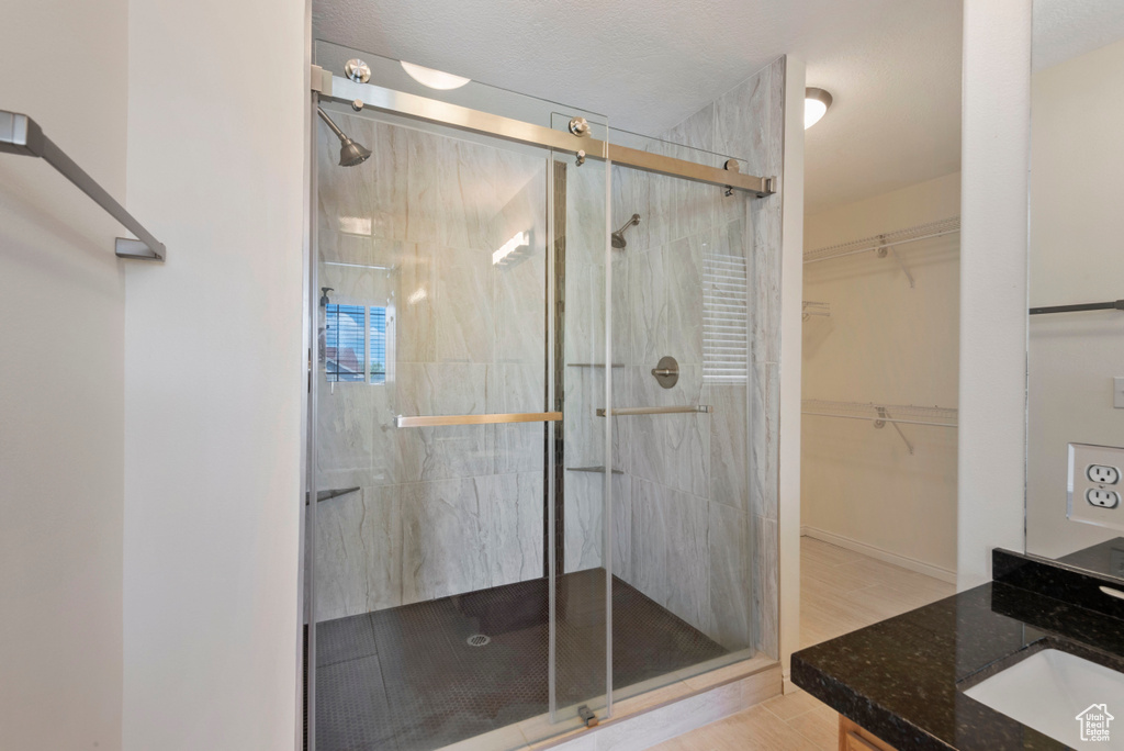 Bathroom featuring hardwood / wood-style floors, vanity, and a shower with door