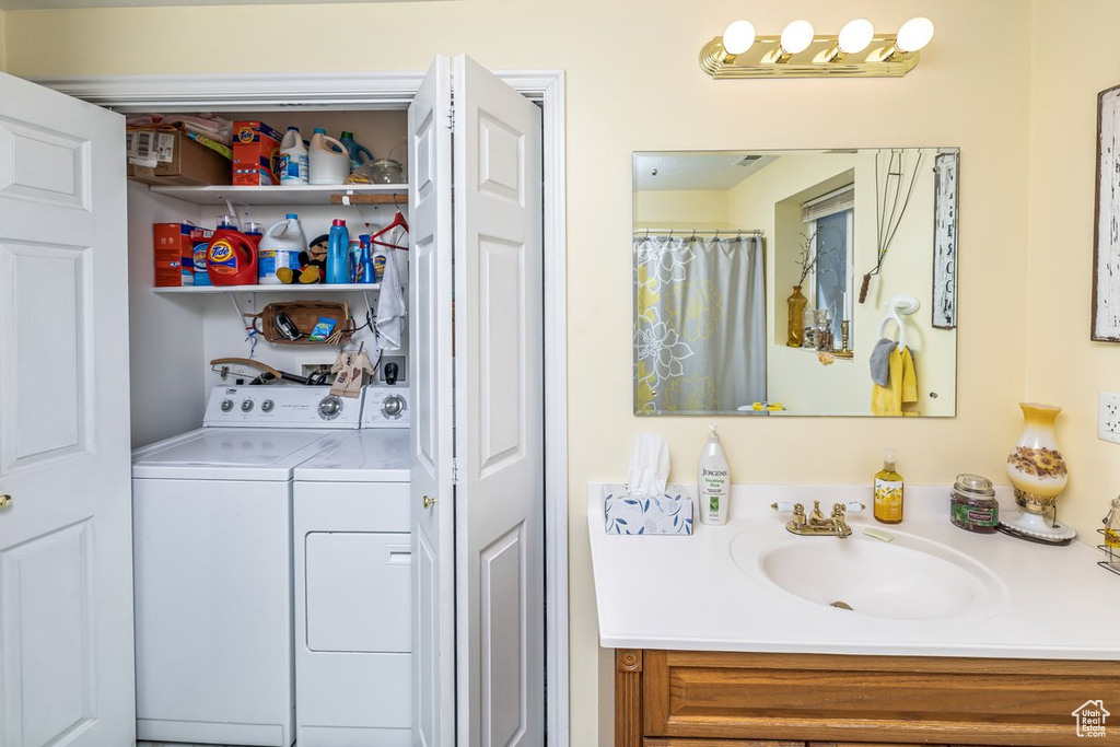 Bathroom featuring vanity with extensive cabinet space and washing machine and dryer