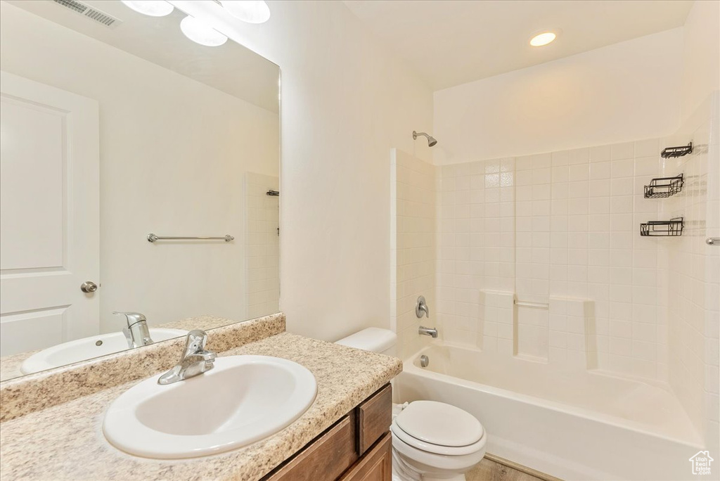 Full bathroom featuring vanity with extensive cabinet space, tub / shower combination, and toilet