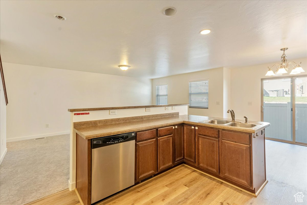 Kitchen with light colored carpet, decorative light fixtures, sink, a chandelier, and stainless steel dishwasher