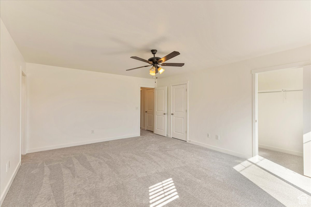 Unfurnished bedroom featuring light colored carpet and ceiling fan